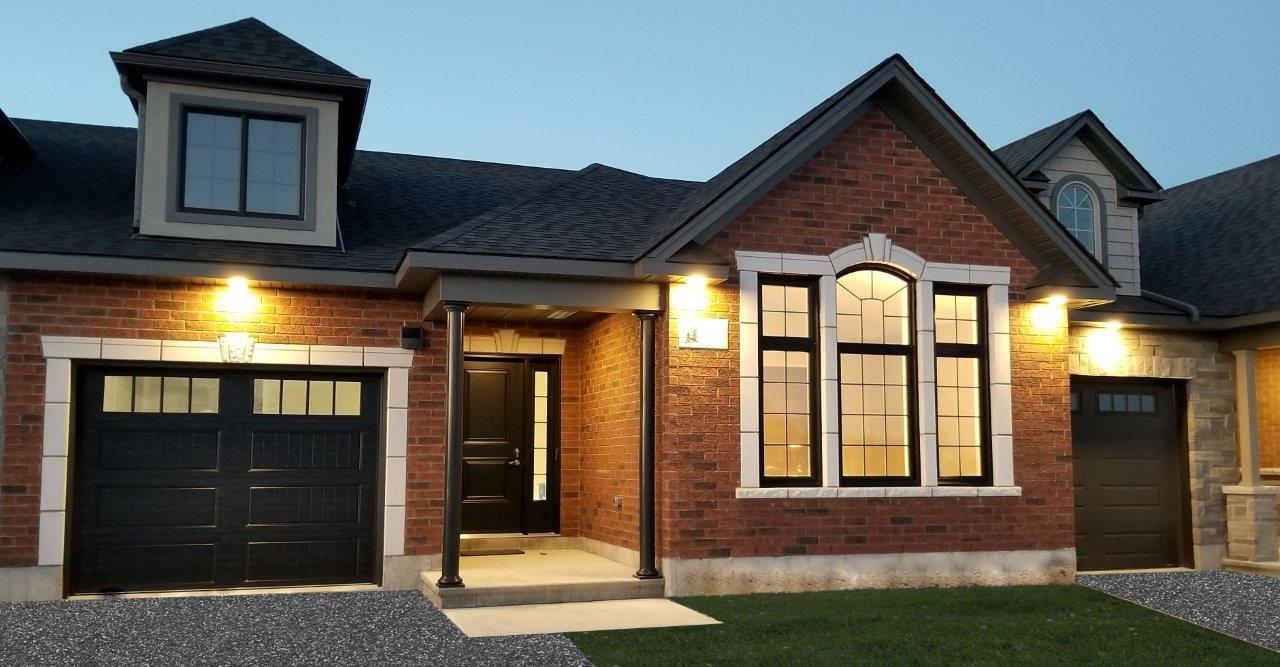 Exterior of brick house at dusk with outdoor lights turned on