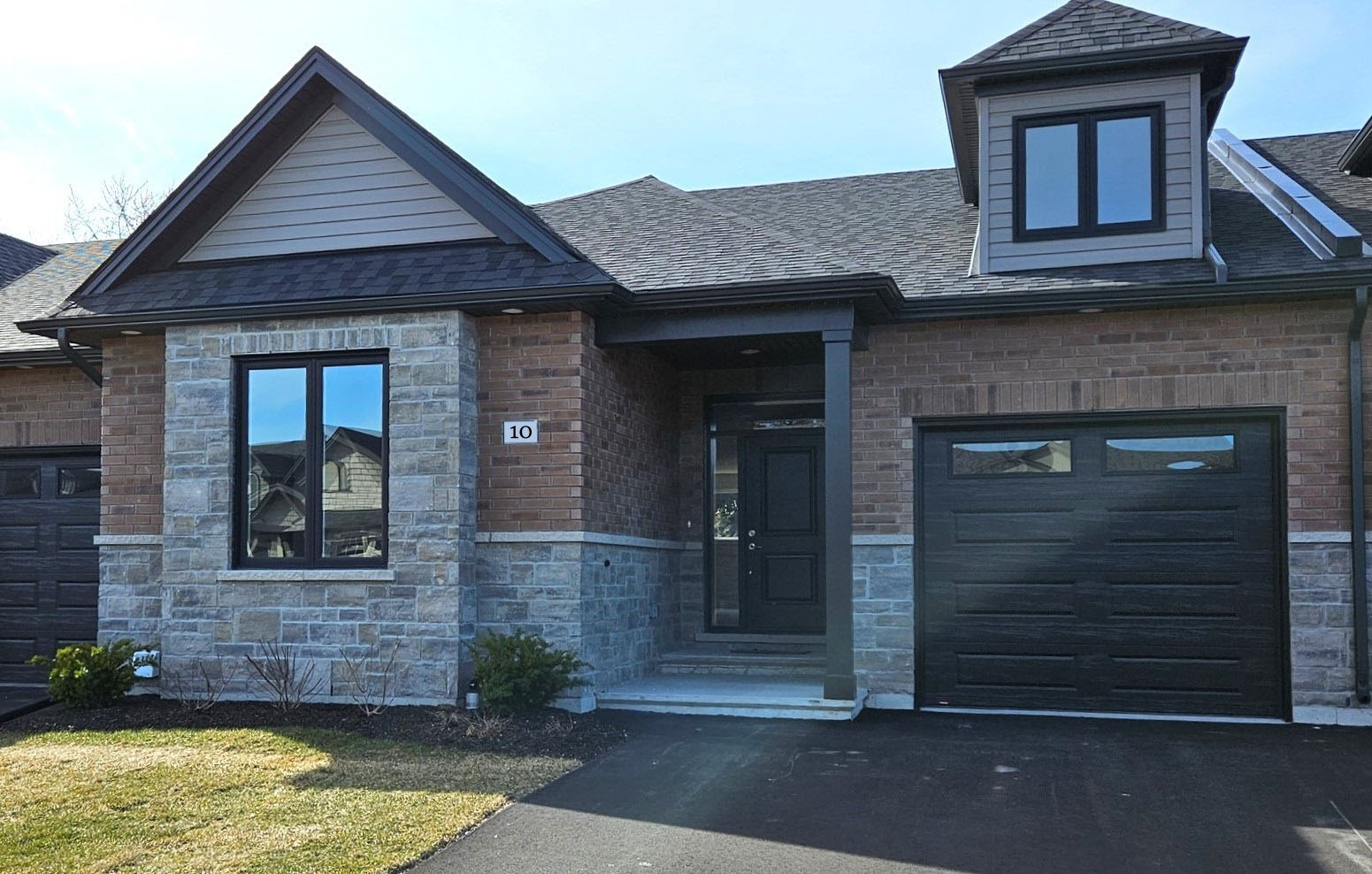 Small brick house that is two-toned mixed masonry with a single attached garage and paved driveway