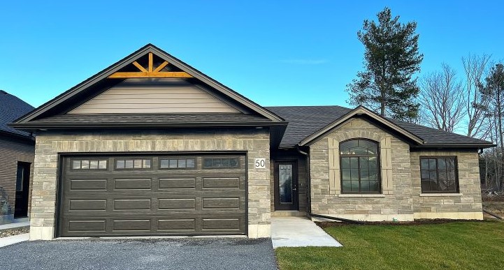 Stone home with double garage and gravel driveway
