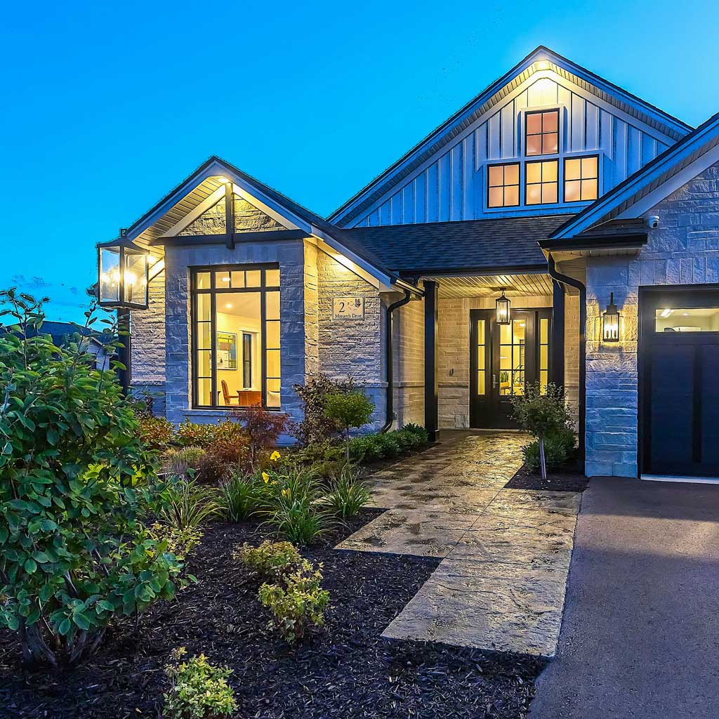 Exterior of home with landscaped garden lit up at dusk