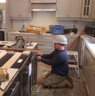 Man wearing a white safety helmet while working on kitchen renovations
